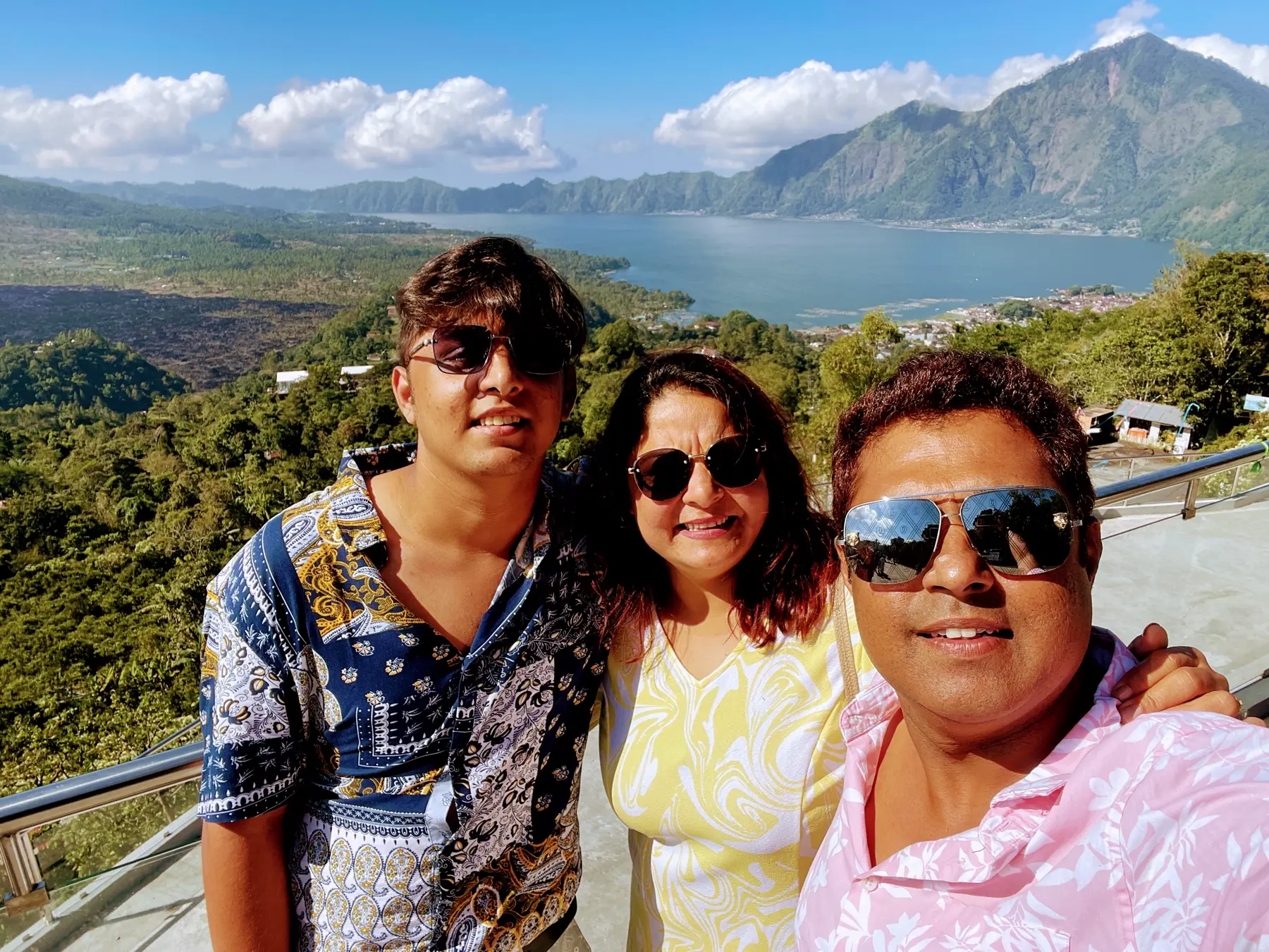 Family smiling by a mountain lake
